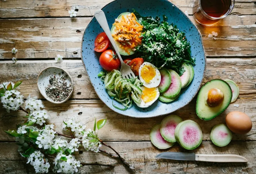 A bowl of vegetables and grains on a table.