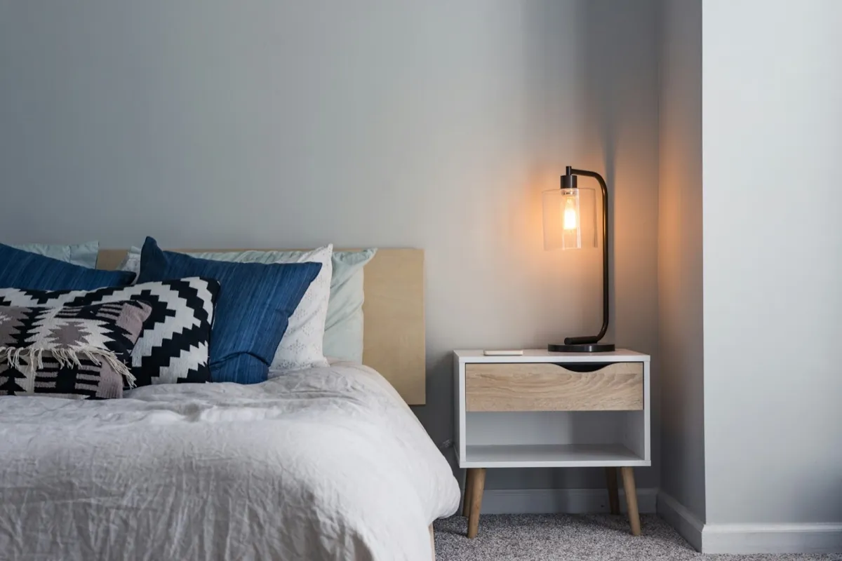 A bedside lamp and a calm bedroom at night.